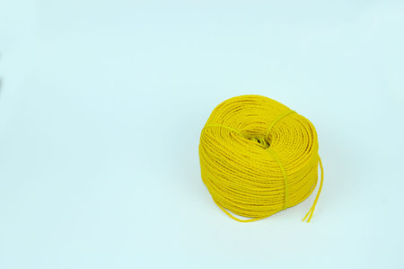 A roll of yellow nylon rope with on white background.