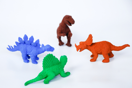 Triceratops, Stegosaurus, Spinosaurus and Tyrannosaurus dinosaur model made from multicolor rubber isolated on white background.の写真素材
