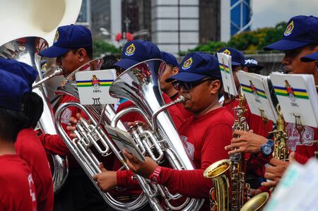 KUALA LUMPUR, MALAYSIA -FEBRUARY 22, 2017: Brass band player is playing a musical instrument while guided by musical notes.のeditorial素材