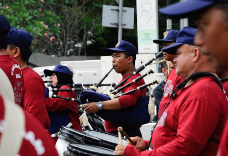 KUALA LUMPUR, MALAYSIA -FEBRUARY 22, 2017: Brass band player is playing a musical instrument while guided by musical notes.のeditorial素材
