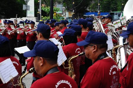 KUALA LUMPUR, MALAYSIA -FEBRUARY 22, 2017: Brass band player is playing a musical instrument while guided by musical notes.のeditorial素材