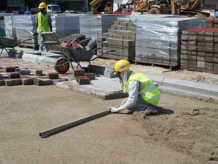 MALACCA, MALAYSIA -MAC 16, 2017: Construction workers levelling sand at the construction site. Sand...