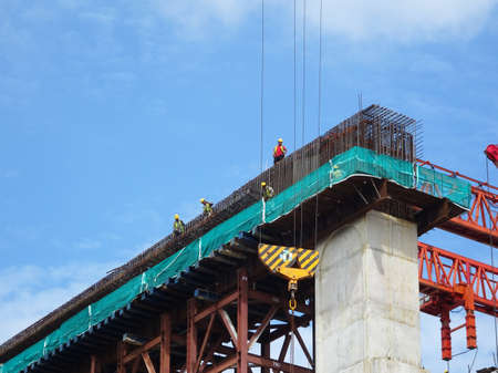 MALACCA, MALAYSIA -MARCH 14, 2020: Construction workers working at height at the construction site. They are supplied with harnesses and other safety equipment to prevent them from having an accident.の写真素材