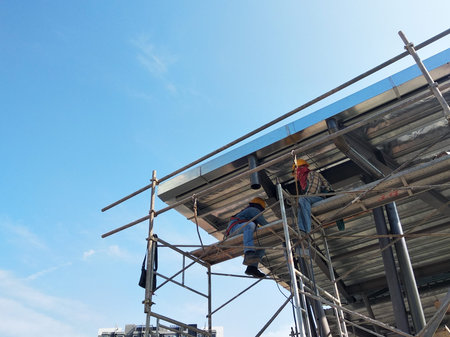MALACCA, MALAYSIA -MARCH 14, 2020: Construction workers working at height at the construction site. They are supplied with harnesses and other safety equipment to prevent them from having an accident.の写真素材