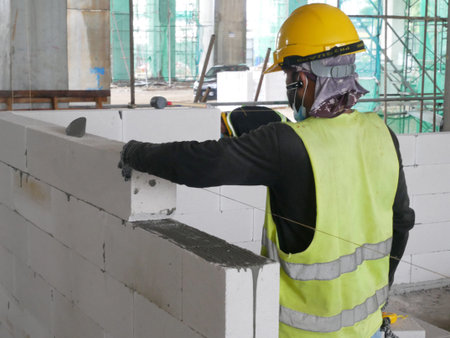 Blockwork by construction workers at the construction site. Workers laying the AAC brick and stacked...