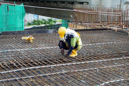 IPOH, MALAYSIA -JUNE 23, 2020: Construction workers fabricating steel reinforcement bar at the...