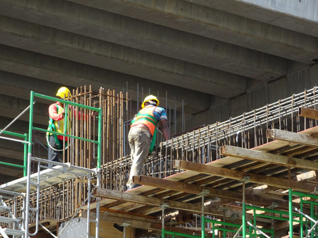 MALACCA, MALAYSIA -MARCH 2, 2020: Construction workers working at height install reinforcement bars...