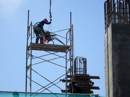 MALACCA, MALAYSIA -MARCH 2, 2020: Construction workers working at height install reinforcement bars...