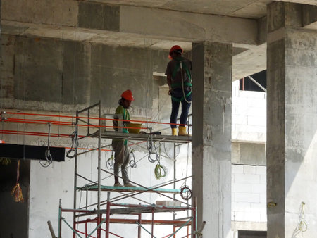 MALACCA, MALAYSIA -MARCH 2, 2020: Construction workers working at height install reinforcement bars...