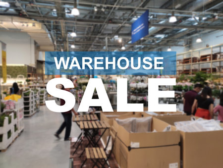 The word WAREHOUSE SALE is clearly written against the background of an image of a department store in a large warehouse. The image has been blurred.の写真素材