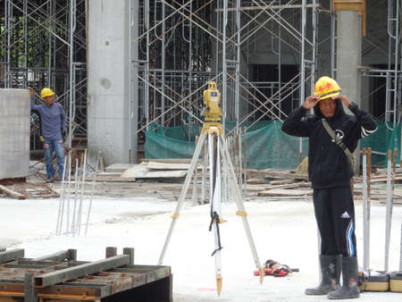 KUALA LUMPUR, MALAYSIA -JULY 16, 2020: Surveyor with survey equipment at the construction site. Surveyors help set the location and level at the construction site.のeditorial素材