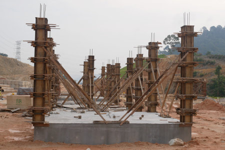 KUALA LUMPUR, MALAYSIA -SEPTEMBER 19, 2020: Column timber formwork and reinforcement bar at the construction site. Installed by construction workers. The structure supported by temporary wood support.のeditorial素材