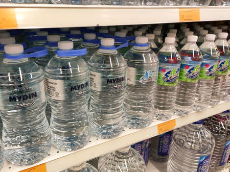 KUALA LUMPUR, MALAYSIA -APRIL 15, 2020: Drinking water is packaged and in plastic bottles and labelled with various brands. Displayed on a shelf inside a supermarket.のeditorial素材
