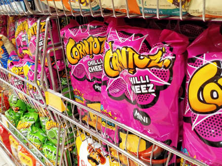 KUALA LUMPUR, MALAYSIA -APRIL 27, 2020: Selective focused of packed miscellaneous brand and type of junk foods & snacks on rack and display for sale in the supermarket. Each has its own price tag.のeditorial素材