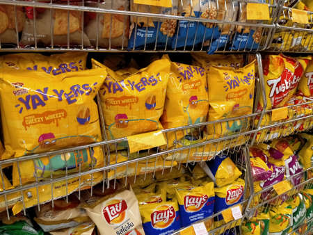 KUALA LUMPUR, MALAYSIA -APRIL 27, 2020: Selective focused of packed miscellaneous brand and type of junk foods & snacks on rack and display for sale in the supermarket. Each has its own price tag.のeditorial素材