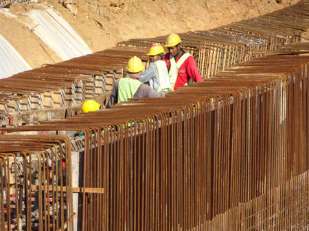 SEREMBAN, MALAYSIA -MARCH 29, 2020: Construction workers fabricating steel reinforcement bar at the construction site. They tied it together using the tiny wires before cover it up using formworks.のeditorial素材