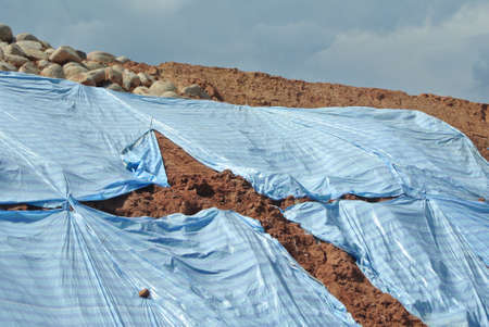 SEREMBAN, MALASIA - MARCH 3, 2019: The plastic sheet is spread over the surface of the slope to prevent erosion. Also to temporarily stabilize the slope before the permanent stabilization work done.のeditorial素材