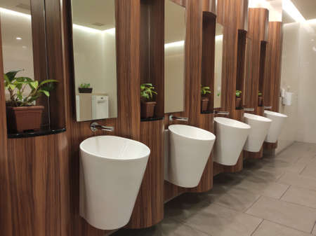 SEREMBAN, MALAYSIA -APRIL 1, 2020: Hand washbasins at the public toilet. Installation complete with face mirror. Made from white glazed ceramic.のeditorial素材