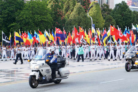 PUTRAJAYA, MALAYSIA -AUGUST 31, 2019: Malaysian teenagers complete with uniforms marching on the road while holding Malaysian state flags. The uniforms used to represent the various uniforms in Malaysのeditorial素材
