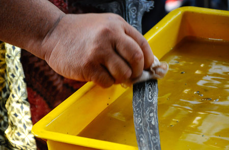 SEREMBAN, MALAYSIA -MAY 01, 2017: A man demonstrate traditional way to clean kris using special...
