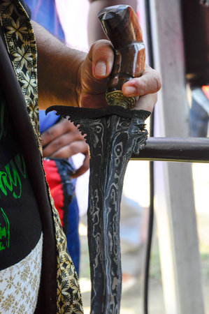 SEREMBAN, MALAYSIA -MAY 01, 2017: A man demonstrate traditional way to clean kris using special chemical and calamondin (citrus microcarpa). A ritual with mystic believe.のeditorial素材