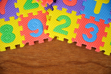 Rubber mat with colorful alphabet design isolated on wood texture board as background.