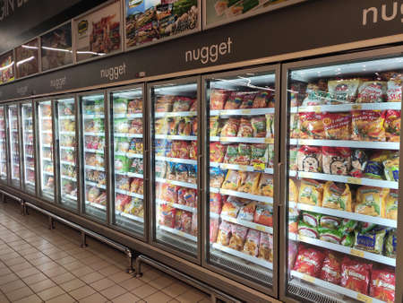 KUALA LUMPUR, MALAYSIA -MARCH 16, 2020: Packed chicken nugget in various brands placed in display chiller refrigerator inside the huge supermarket.のeditorial素材