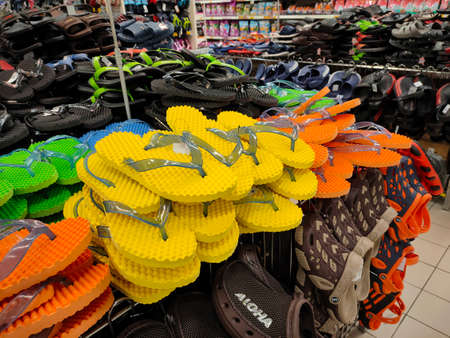KUALA LUMPUR, MALAYSIA -AUGUST 18, 2020: Colorful pair of slippers and shoes displayed for sale. Each pair has a price tag for the convenience of customers.のeditorial素材
