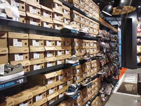 KUALA LUMPUR, MALAYSIA -AUGUST 18, 2020: Colorful pair of slippers and shoes displayed for sale. Each pair has a price tag for the convenience of customers.のeditorial素材