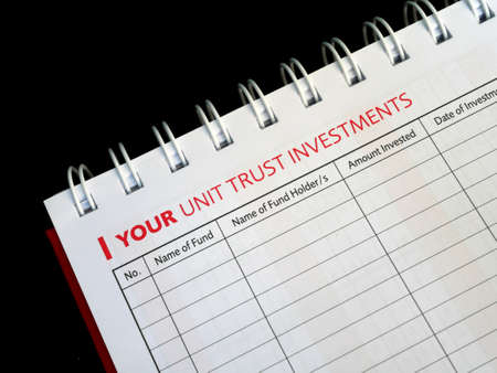 Selected focused on Unit Trust Investment text found on one page of a notebook. Be the title to a table of unit trust investment schedules that is still empty.の写真素材