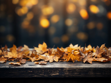 Autumn leaves on wooden table and bokeh lights background.の素材