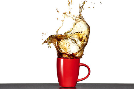 Splash of tea in cup isolated on white.の写真素材