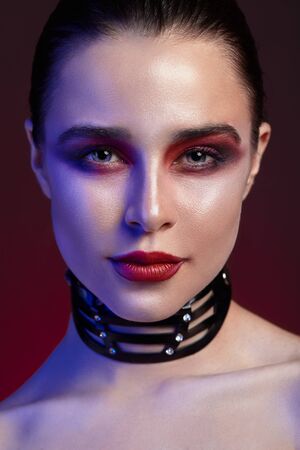 Beautiful portrait of a young beautiful girl with bright makeup. Red shadow and lips.の写真素材