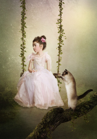 Sad princess on the swing Cat looking at the girlの写真素材