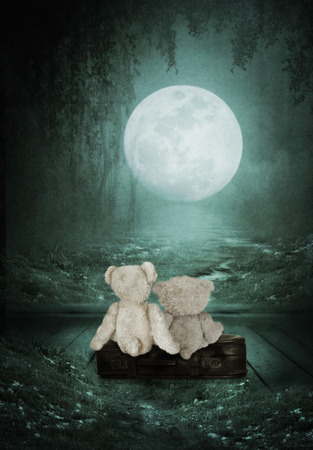 Teddy Bears are sitting on the old suitcase in the roomの写真素材