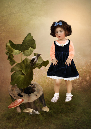 The little girl with surprised look is looking on crowの写真素材