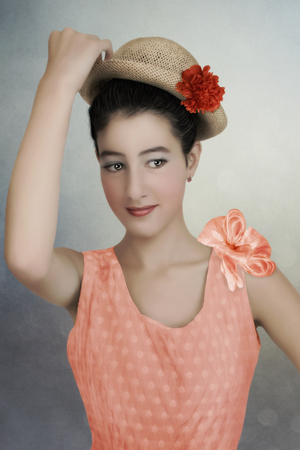 Portrait of young girl smiling in straw hat with flowerの写真素材