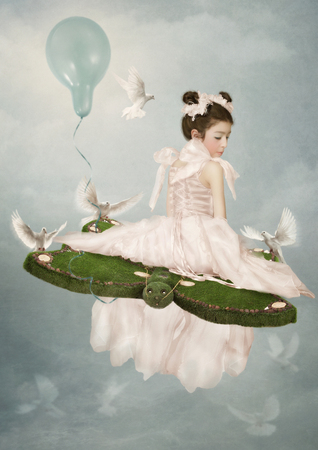 The little girl in beautiful dress surrounded by pigeonsの写真素材