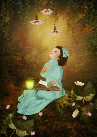 Little girl arms folded sitting on a stump in the forestの写真素材