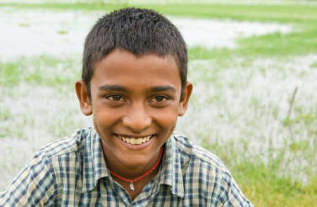 A portrait of a smiling Indian fisherman's boy at a lake.の写真素材