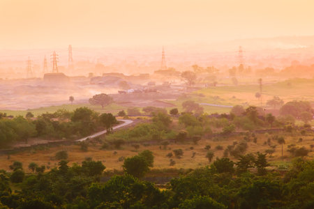 Electrical power distribution towers in misty landscape.