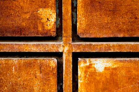 Closeup of rusted textured gate showing cross symbol.の写真素材