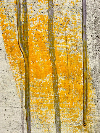 Weathered wall closeup shot showing yellow & grey colors & textureの写真素材