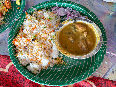 Fish curry Thali from an indian cuisine, food platter consists of fish curry, rice and onions served in disposable plateの写真素材