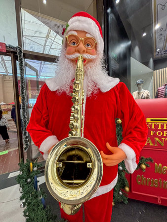 statue of a santa claus playing a saxophone , display is in the shopping mallの写真素材