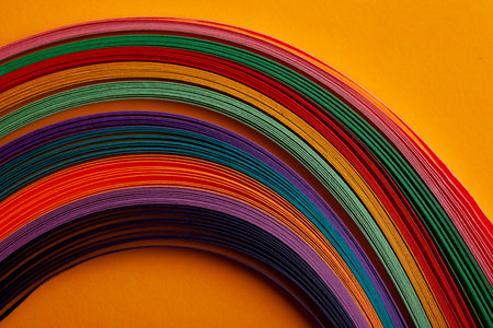 A colorful strip of paper with a yellow background. The paper is in a rainbow of colors and is arranged in a lineの写真素材