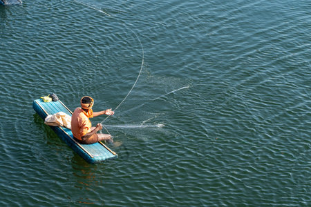Fisherman fishing in a boat on a lake at Maharashtra, India