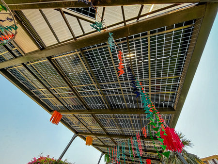 A colorful canopy with paper decorations hanging from it. The decorations are in various colors and...