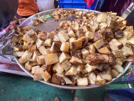 A pile of of garadu (Dioscorea bulbifera or air potato) chips on a plate. The chips are cut into small pieces and are scattered all over the plateの写真素材