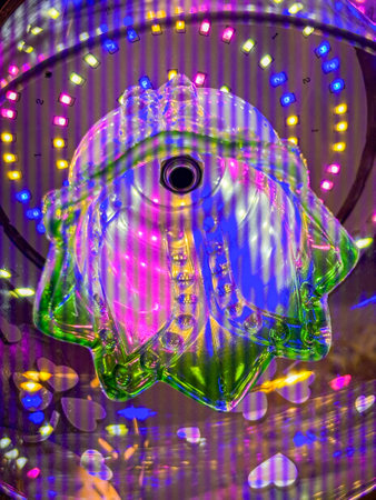 A green and white object with a purple and blue background. The object is a flower and the background is a colorful lightの写真素材